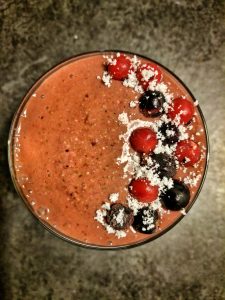 A breakfast idea. Glass of Spinach, Mixed Berry and Oat Smoothie